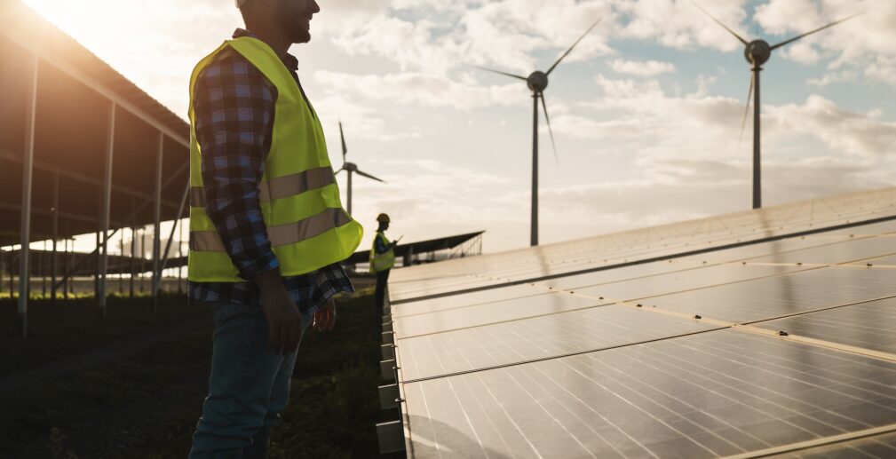 Man working for solar panels and wind turbines - Renewable energy concept - Focus on male worker face Man working for solar panels and wind turbines - Renewable energy concept - Focus on male worker face